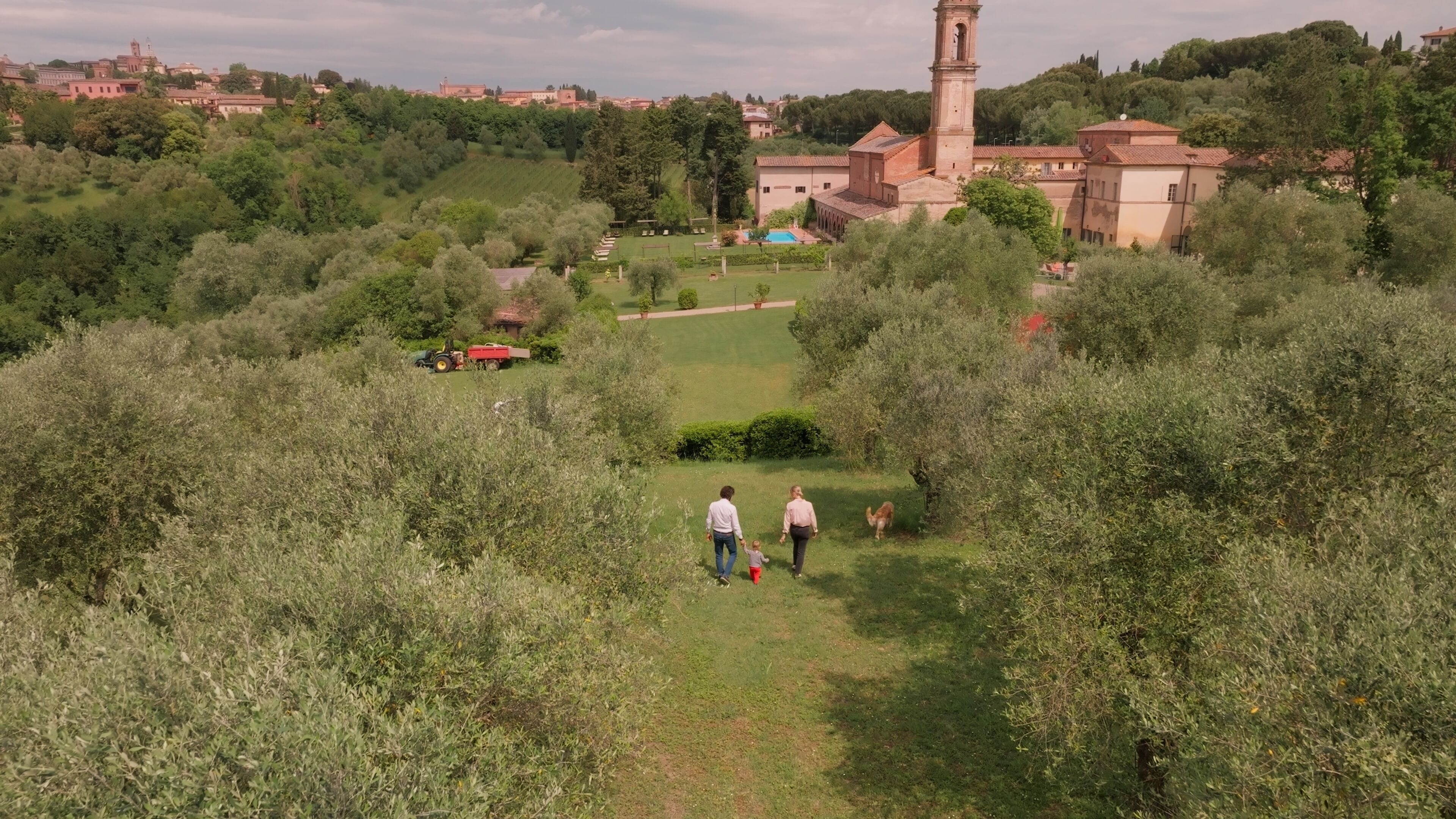 A rural landscape with a path leading to a building with a tower.