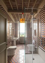 Un bagno con pavimento a scacchi, un lavandino bianco, un water e uno spazio doccia.