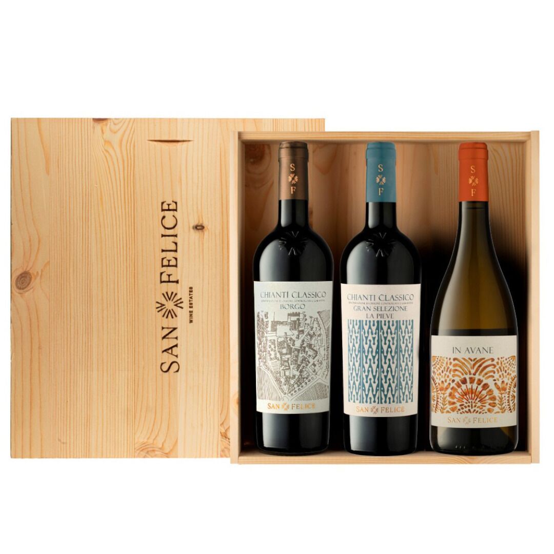 A wooden box containing three bottles of wine, each with distinct labels.