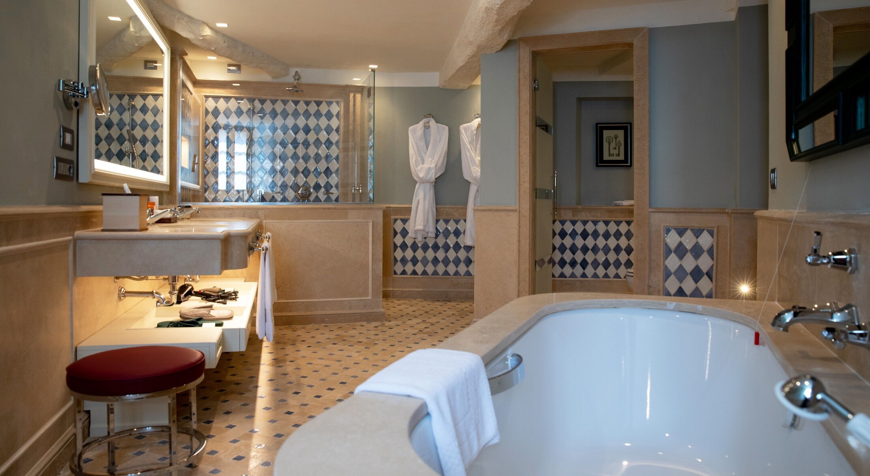 A bathroom with a large bathtub, a sink, a mirror, and a shower area.