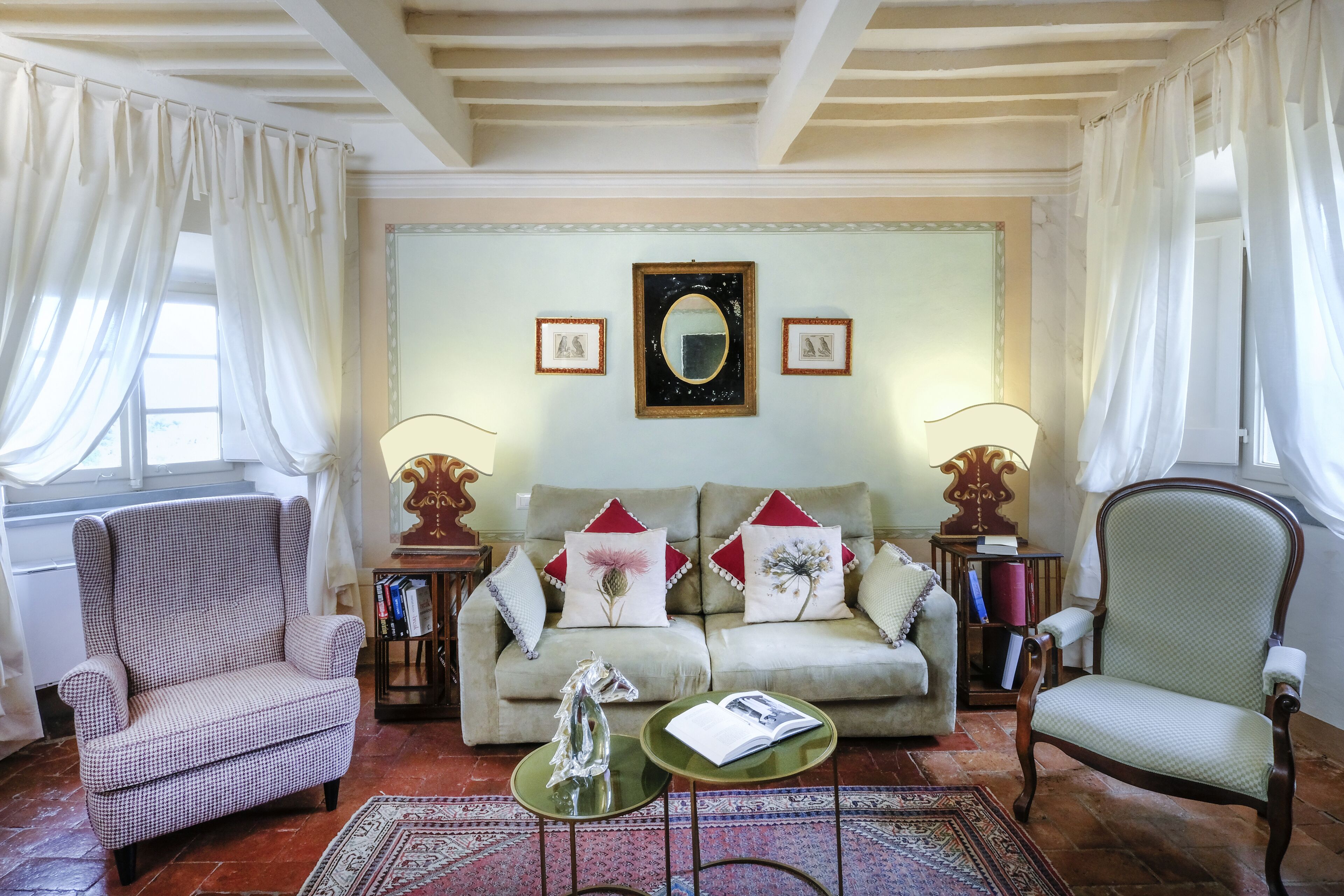 A living room with a sofa, two armchairs, a coffee table, and a patterned rug.