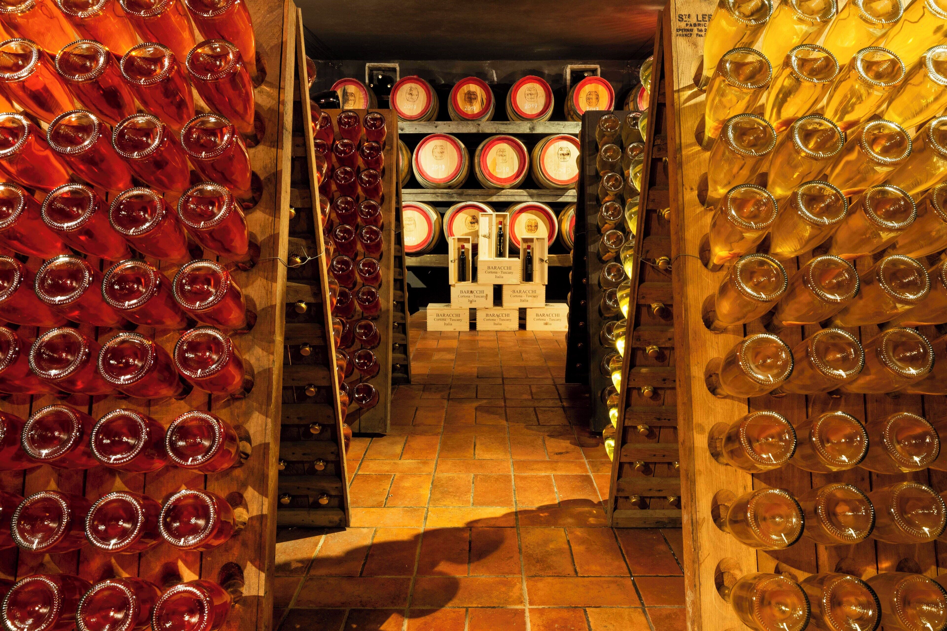 Une cave à vin avec des rangées de bouteilles de vin et de verres.