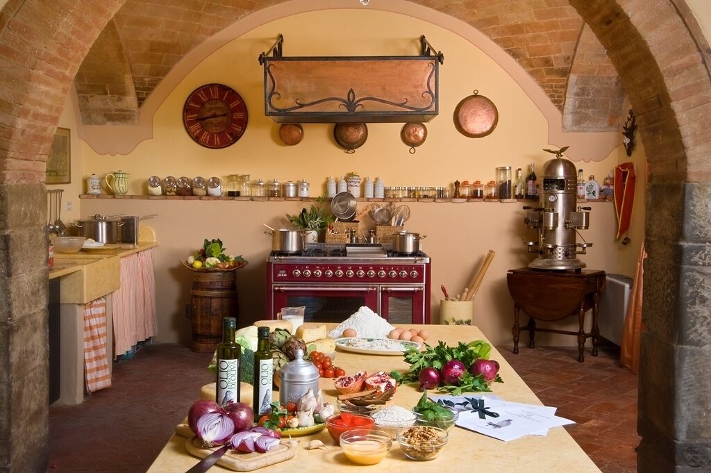 A rustic kitchen with an old-fashioned stove, shelves with jars and bottles, and a variety of fresh ingredients on the counter.
