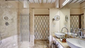 Une salle de bain moderne avec une douche à l’italienne, deux vasques et un grand miroir.