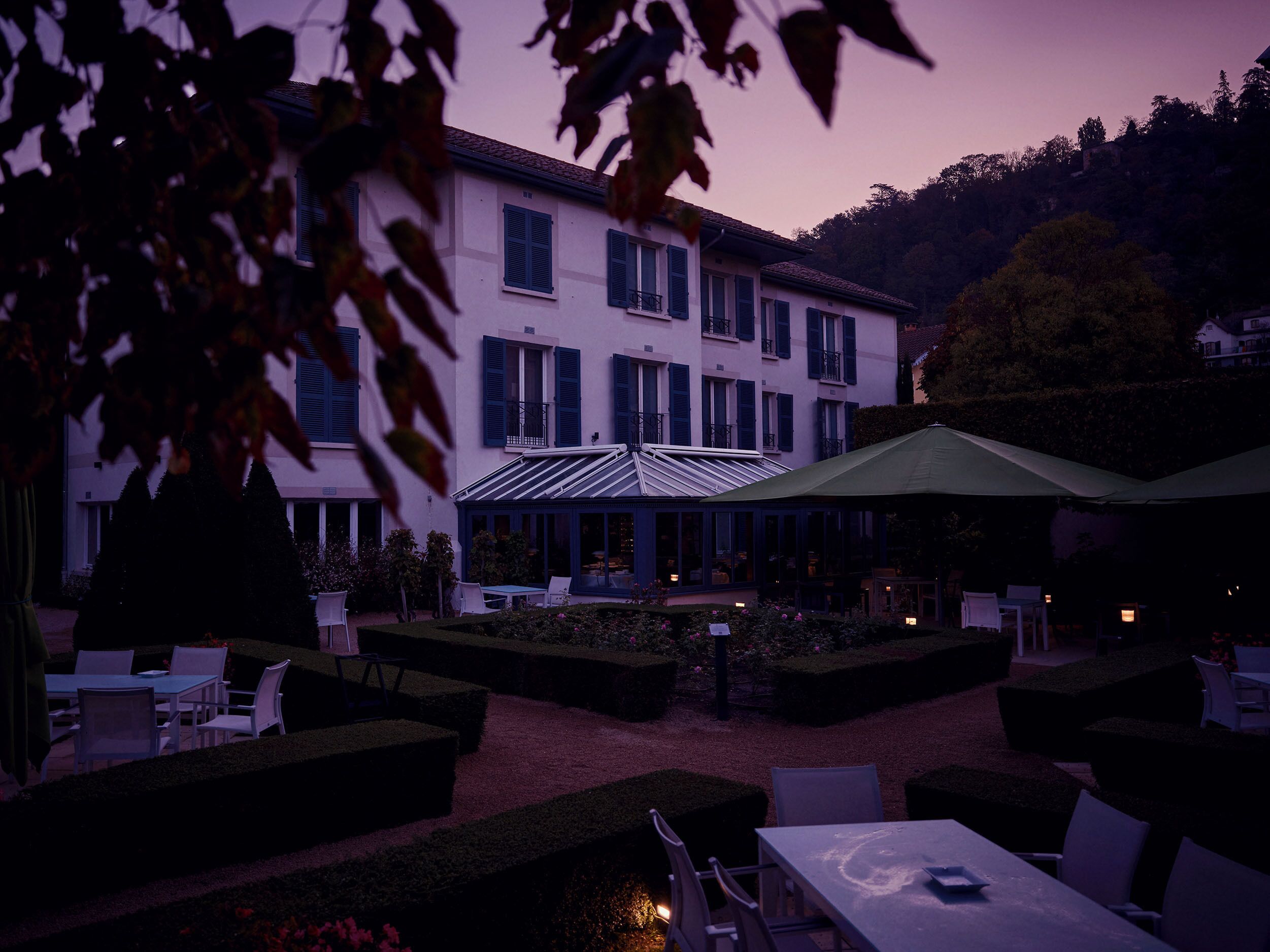 A courtyard with outdoor seating, a covered area, and a building with multiple windows and balconies.