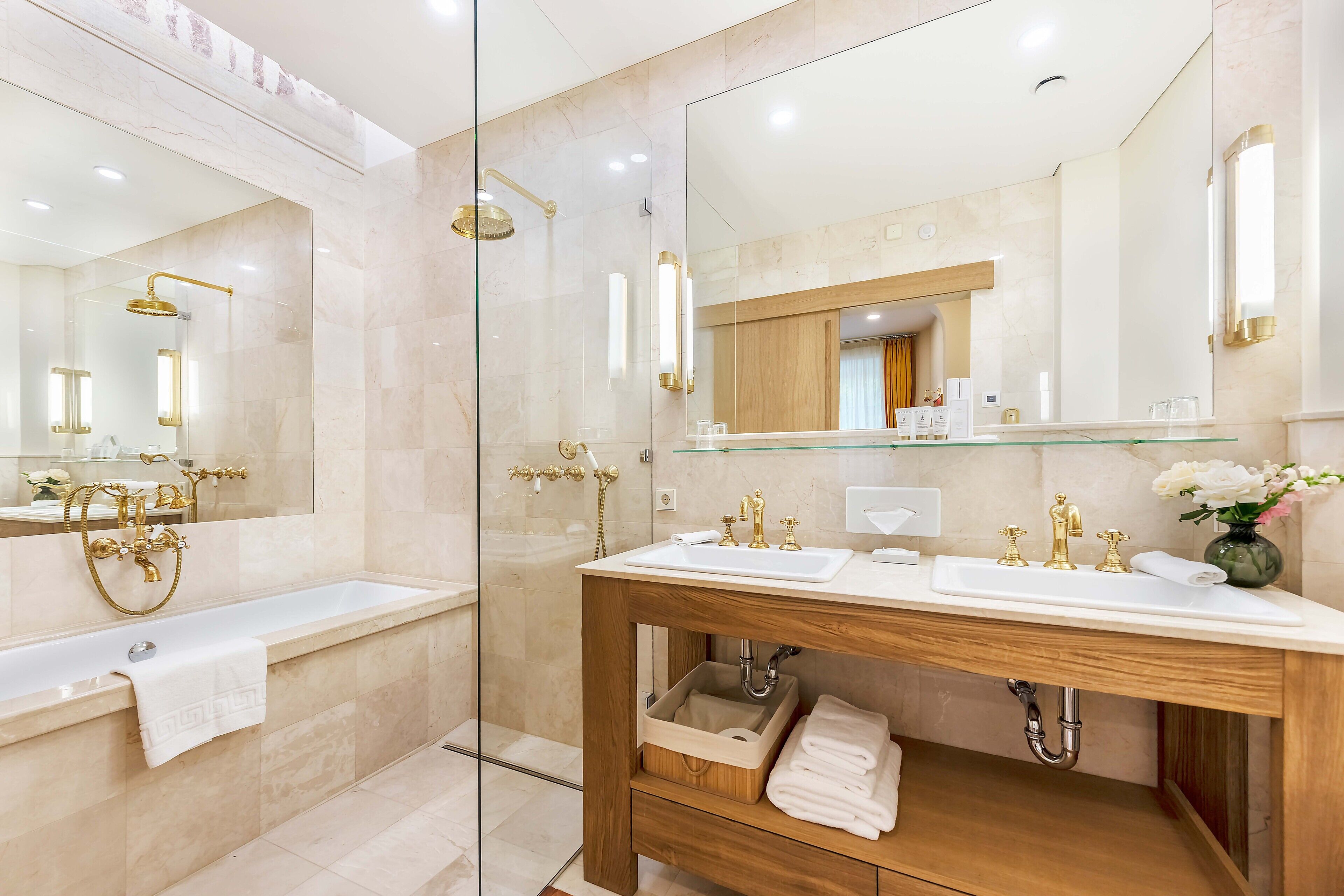 A modern bathroom with a glass-enclosed shower, a wooden vanity with a sink, and a large mirror.