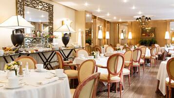 A restaurant with multiple tables and chairs, a bar area with various food items, and decorative lighting.