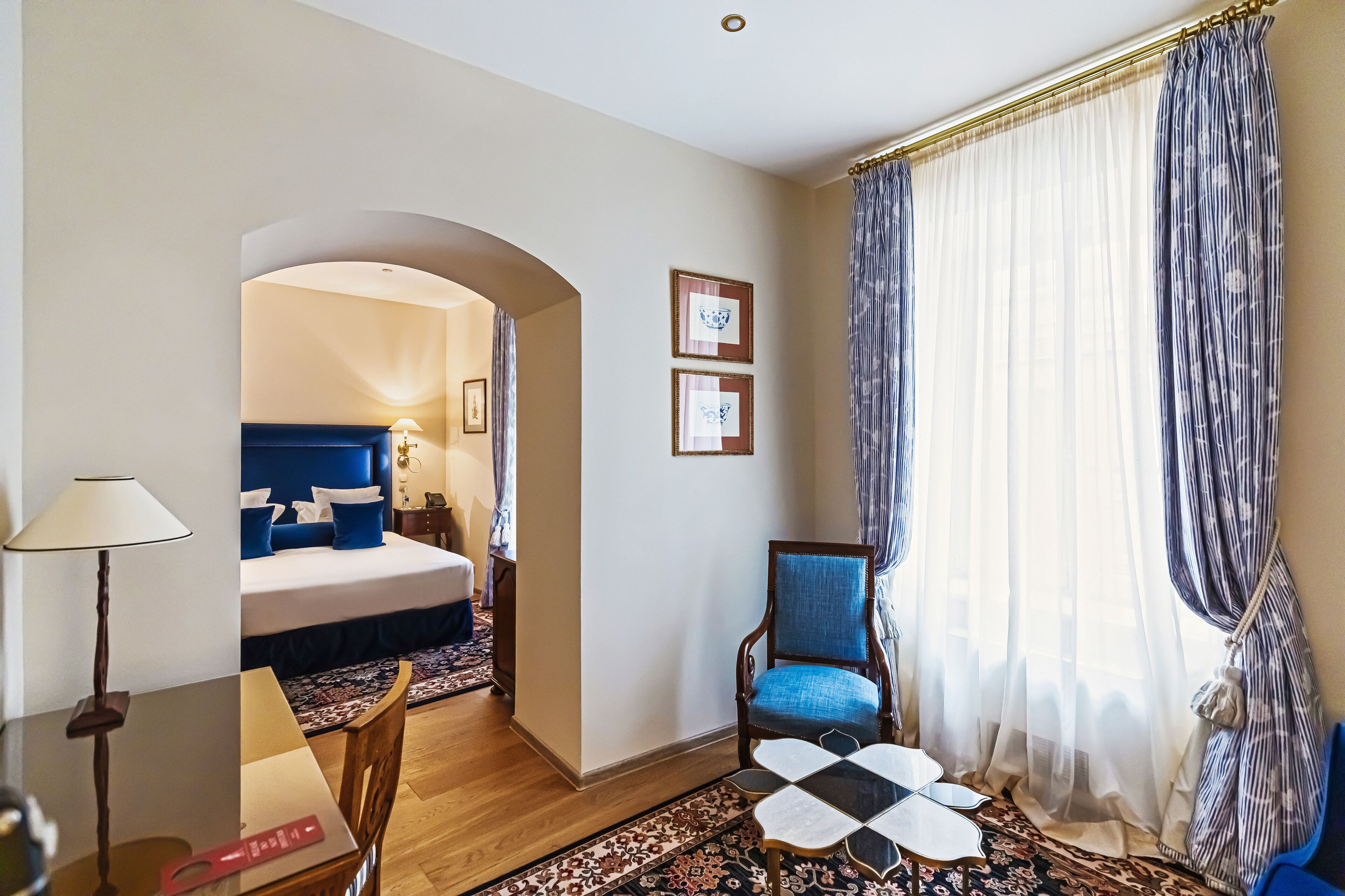 Una habitación de hotel con cama, una silla, una mesa y un escritorio.