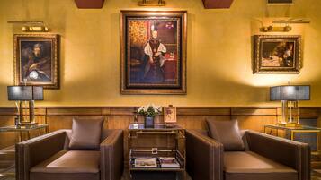 A lobby with two leather armchairs, a coffee table, and framed artwork on the walls.
