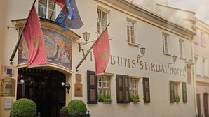 The exterior of the Butis Stiklai Hotel with flags, a signboard, and a mural. - Stikliai Hotel - Relais & Châteaux (Vilnius)