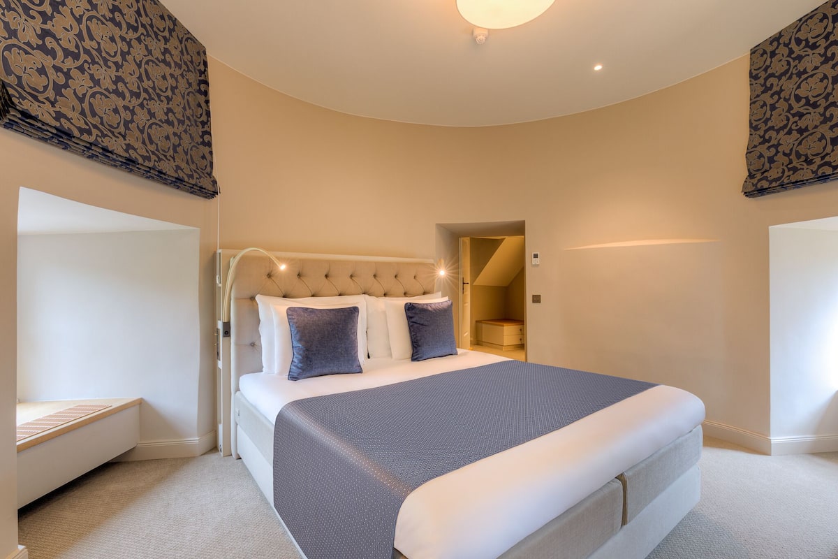 Un dormitorio moderno con una cama grande, una mesita de noche y un armario empotrado.