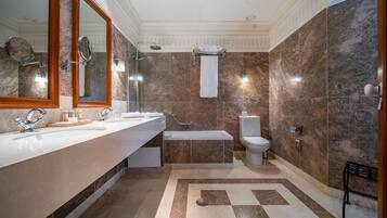 Un baño moderno con dos lavabos, una bañera y un inodoro.