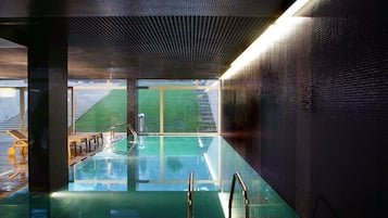 Una piscina cubierta, una piscina al aire libre, tumbonas