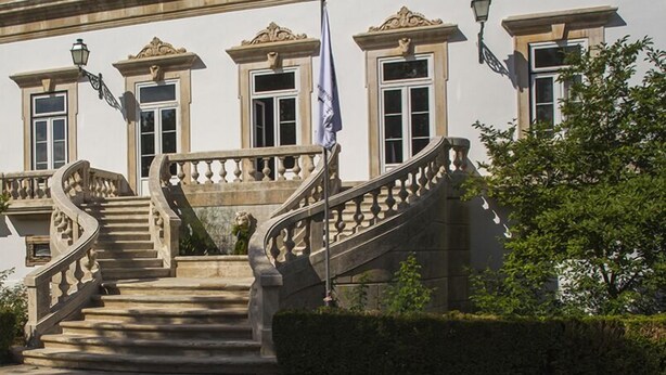 A grand building with a central staircase, ornate architectural details, and a flag. - Quinta Das Lagrimas (Coimbra)