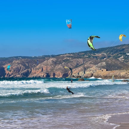 Beach nearby, white sand, beach towels, windsurfing