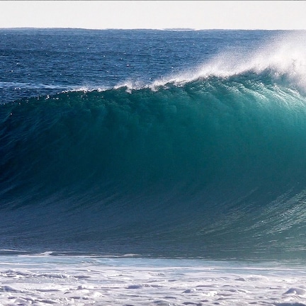 A surfer riding a large wave in the ocean.