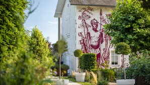 A pathway leading to a building with a mural on the wall.