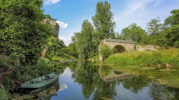 Un río tranquilo con un puente de piedra y un bote.