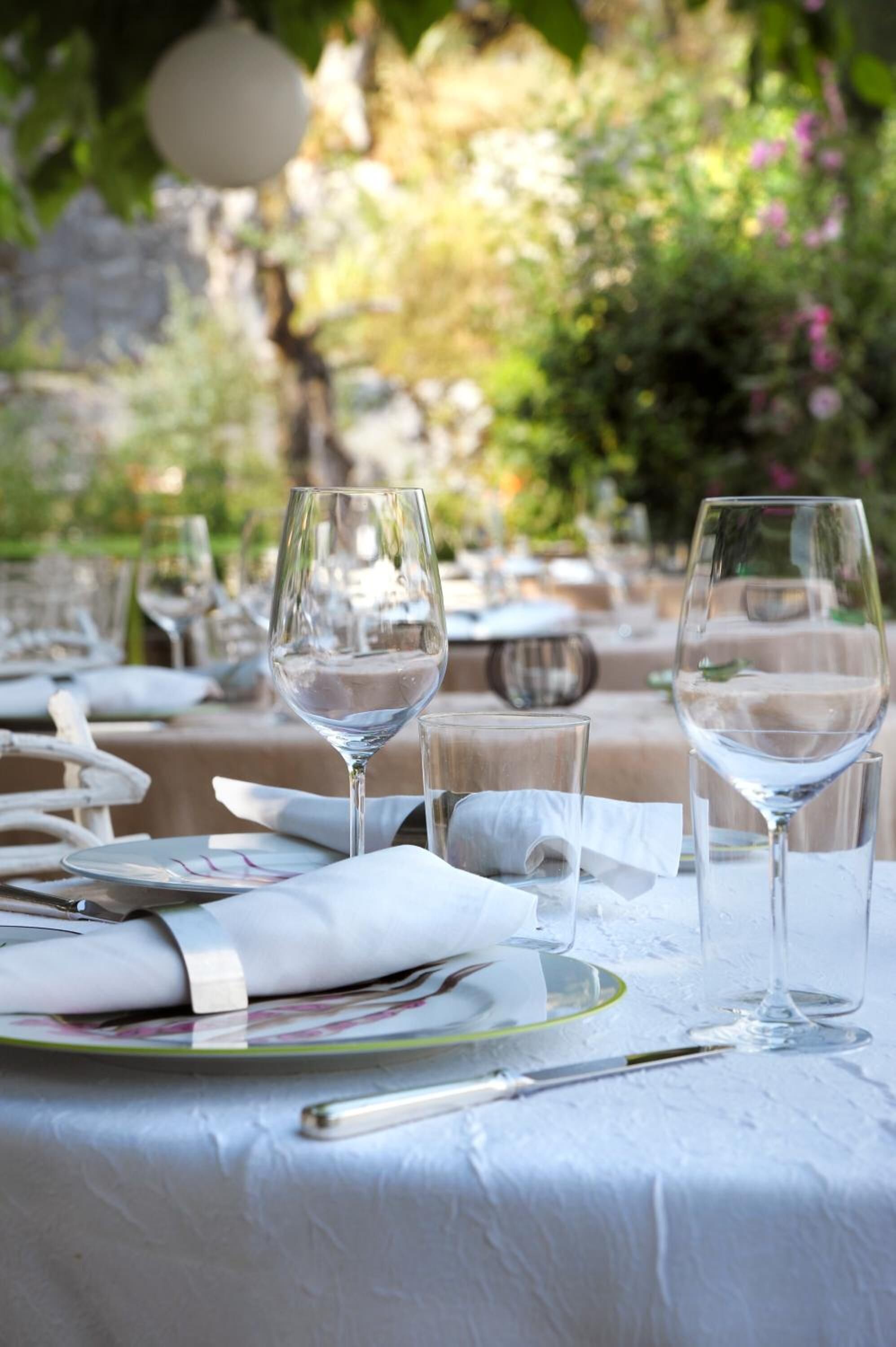 Une table mise pour un repas, avec des verres à vin, des assiettes et des couverts.