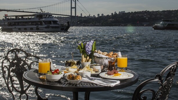A table set with breakfast items and a view of a bridge over water. - Bosphorus Palace Hotel - Special Class (Istanbul)