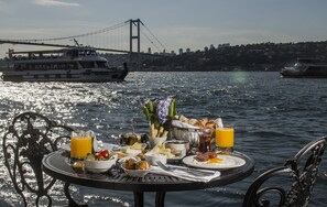 A table set with breakfast items and a view of a bridge over water. - Bosphorus Palace Hotel - Special Class (Istanbul)