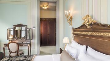 A hotel room with a large bed, a wooden dresser with a mirror, a desk, and a chair.