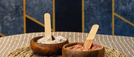 Dos tazones de madera sobre un posavasos tejido con un fondo de tela a rayas.