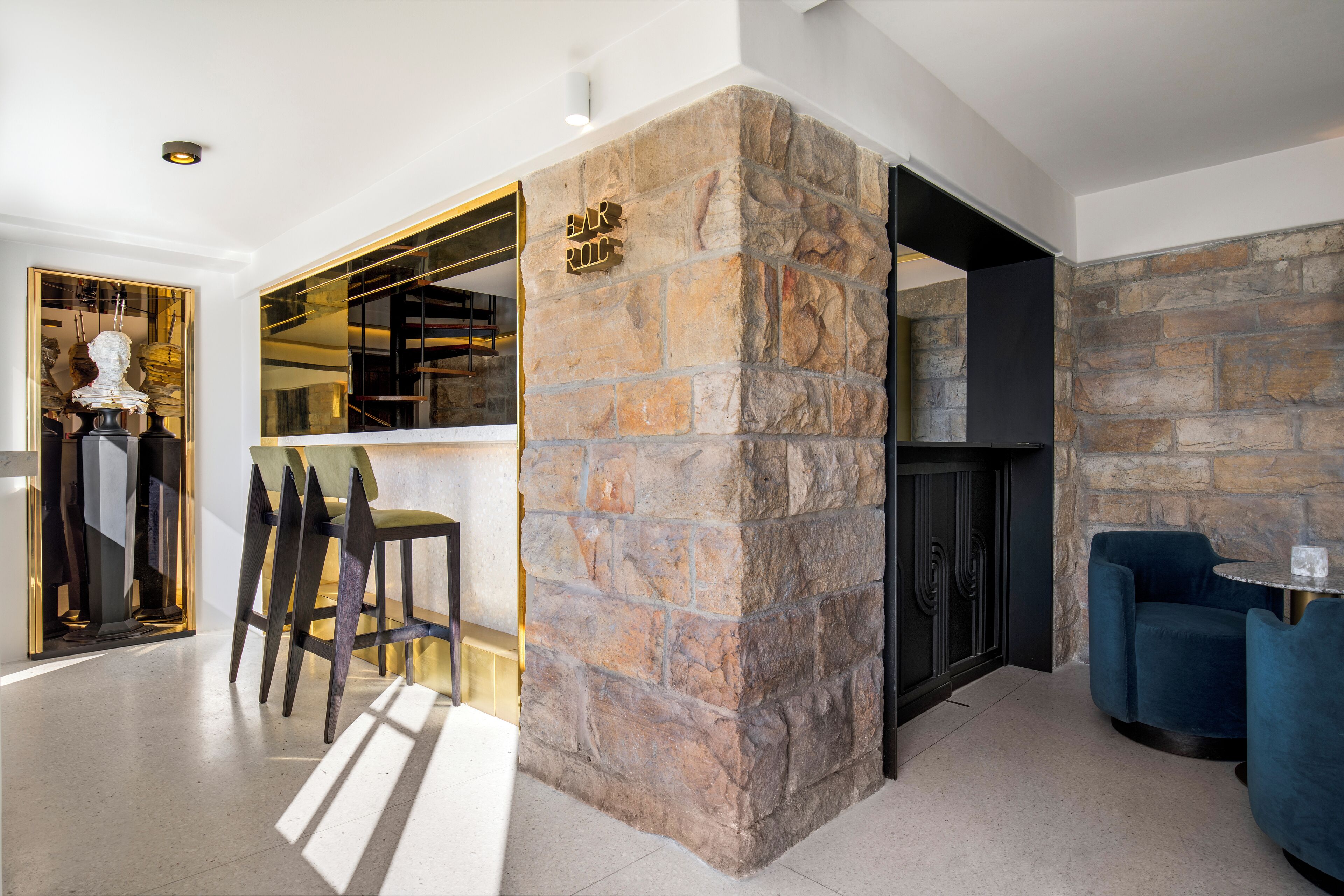 Un interior moderno con una pared de acento de piedra, una zona de bar y asientos.