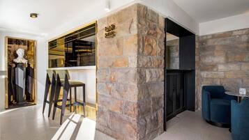 Un interior moderno con una pared de acento de piedra, una zona de bar y asientos.