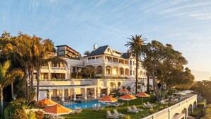 A resort with a pool area, lounge chairs, and a view of the ocean. - Ellerman House (Cape Town)