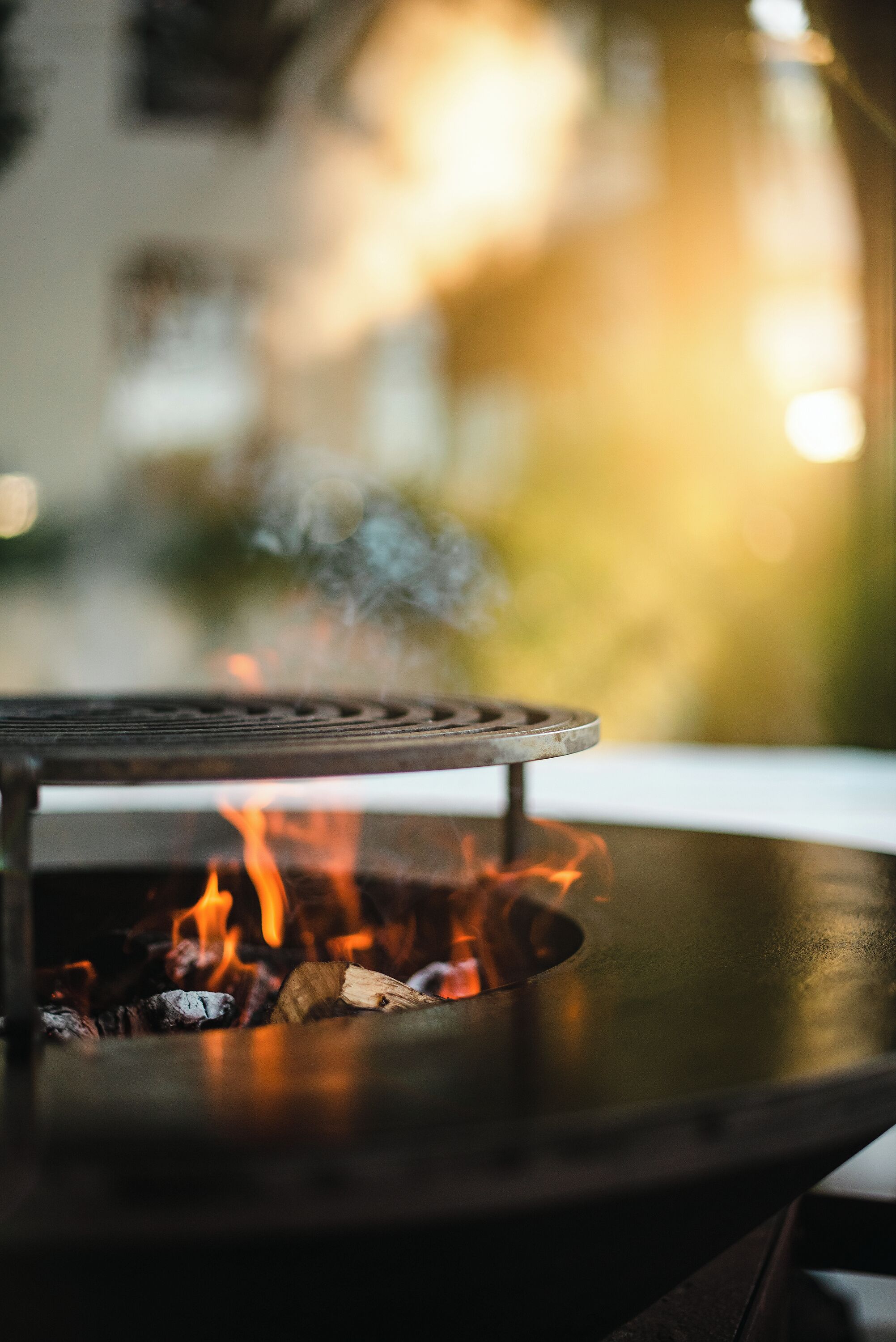 A close-up of a grill with visible flames and smoke, suggesting outdoor cooking facilities.