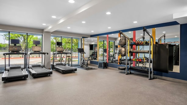 A modern gym with treadmills, stationary bikes, and various exercise equipment. - Hampton Inn by Hilton Addison Dallas (Addison)