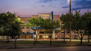A Hampton Inn by Hilton hotel with a modern facade, large windows, and a well-lit entrance. - Hampton Inn by Hilton Addison Dallas (Addison)