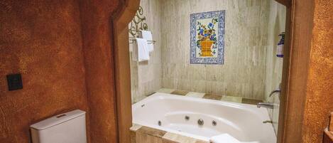 Un baño con bañera, inodoro y zona de ducha.