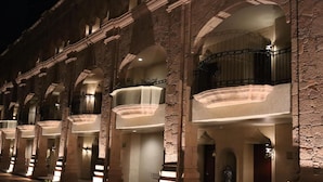 A hotel with multiple balconies, stone arches, and illuminated lighting. - Hilton San Luis Potosi (San Luis Potosi)