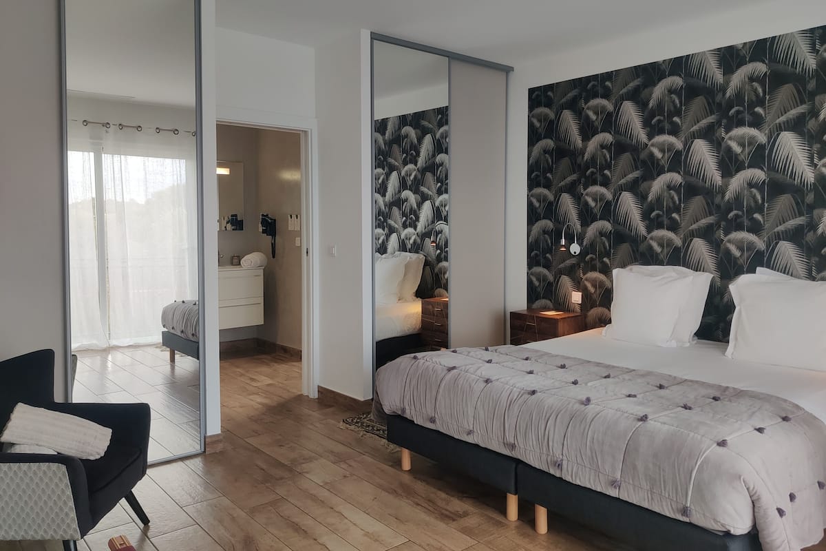 Une chambre moderne avec un grand lit, une table de chevet, une chaise et une armoire.