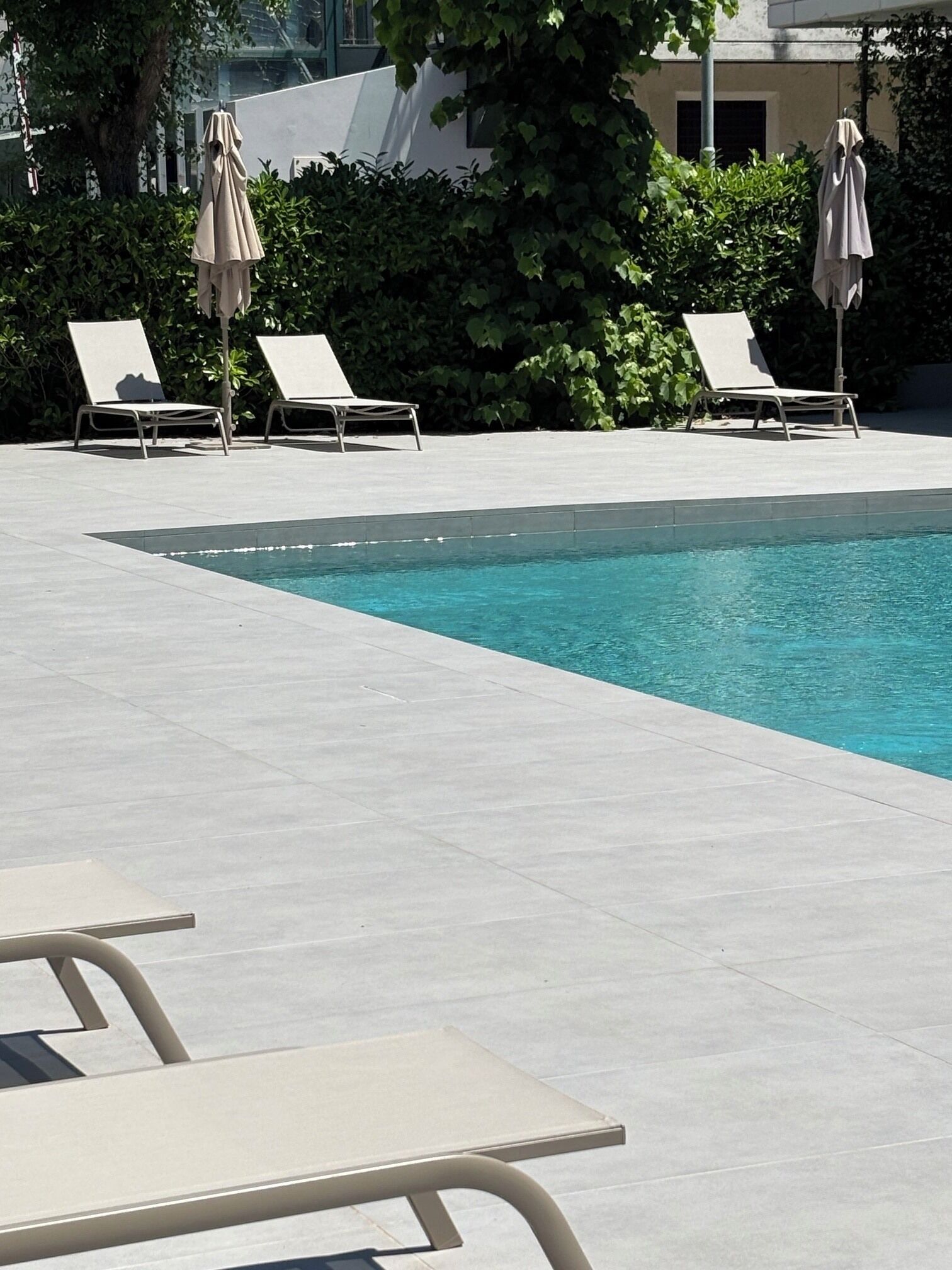 Una piscina al aire libre de temporada, sombrillas