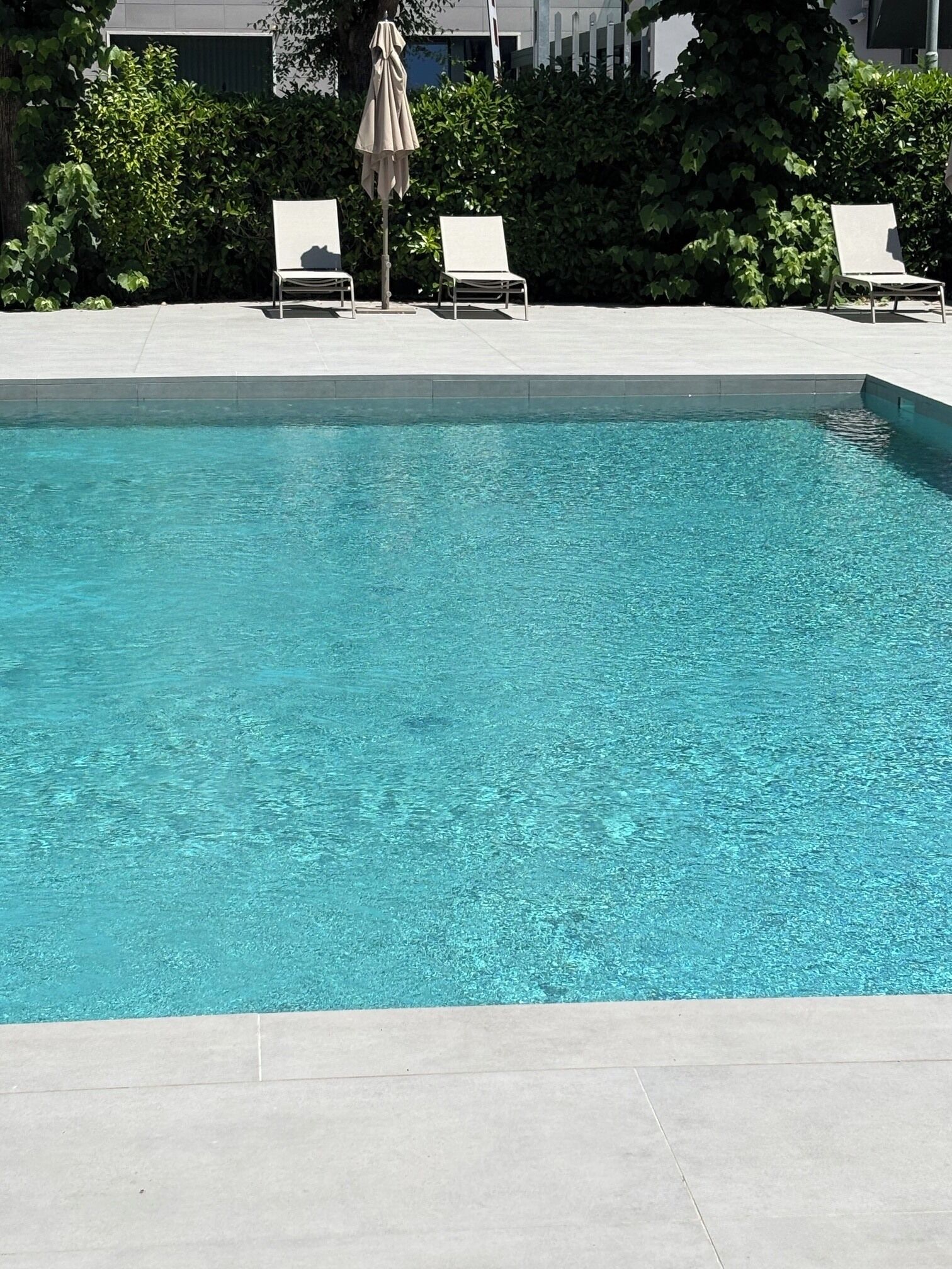 Una piscina al aire libre de temporada, sombrillas