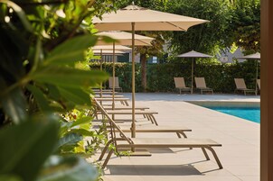 A poolside area with lounge chairs and umbrellas.