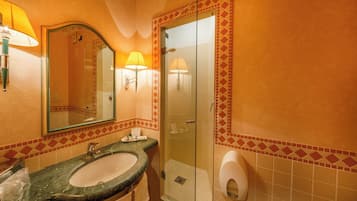 Ein Badezimmer mit Waschbecken, Spiegel, Dusche und Toilettenpapier.