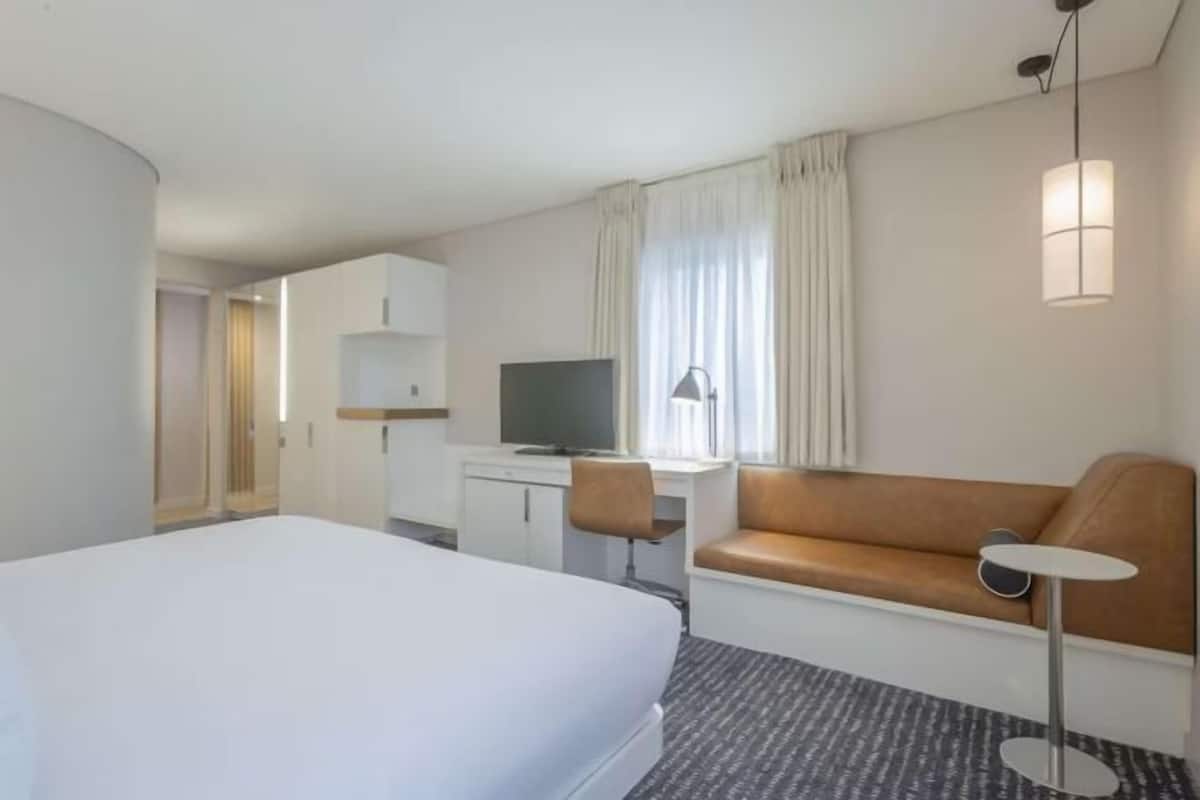 Ropa de cama hipoalergénica y caja de seguridad en la habitación