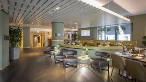 A modern restaurant interior with a bar area, seating, and a view of the outside.