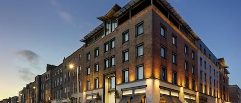 A multi-story hotel with a brick facade, large windows, and a flat roof.