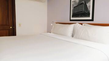 Una cama bien hecha en una habitación de hotel con un cuadro en la pared.