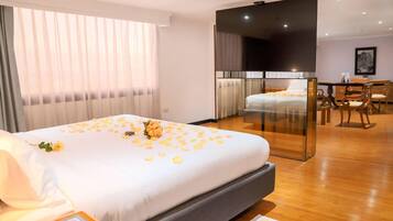 Una habitación de hotel con cama, escritorio y zona de comedor.