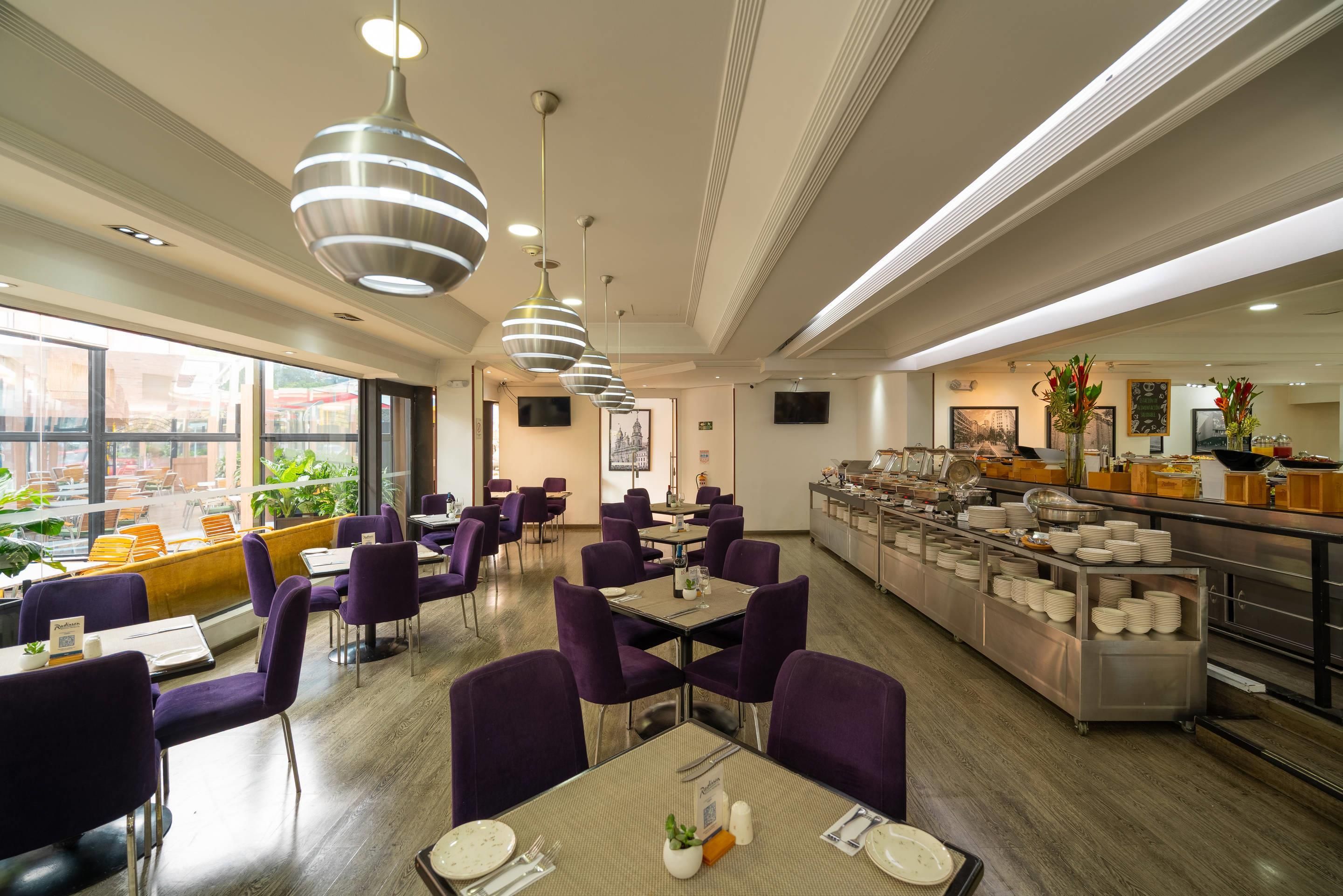 Un restaurante con sillas, mesas y una zona de bufé morados.