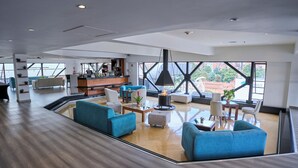 A spacious lobby with modern furniture, a bar area, and large windows offering city views. - Radisson Bogota Metrotel (Bogotá)