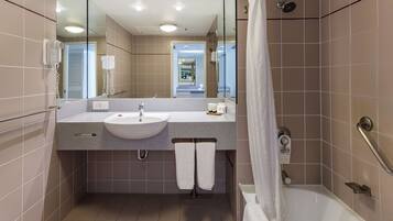 A modern bathroom with a sink, mirror, and shower.