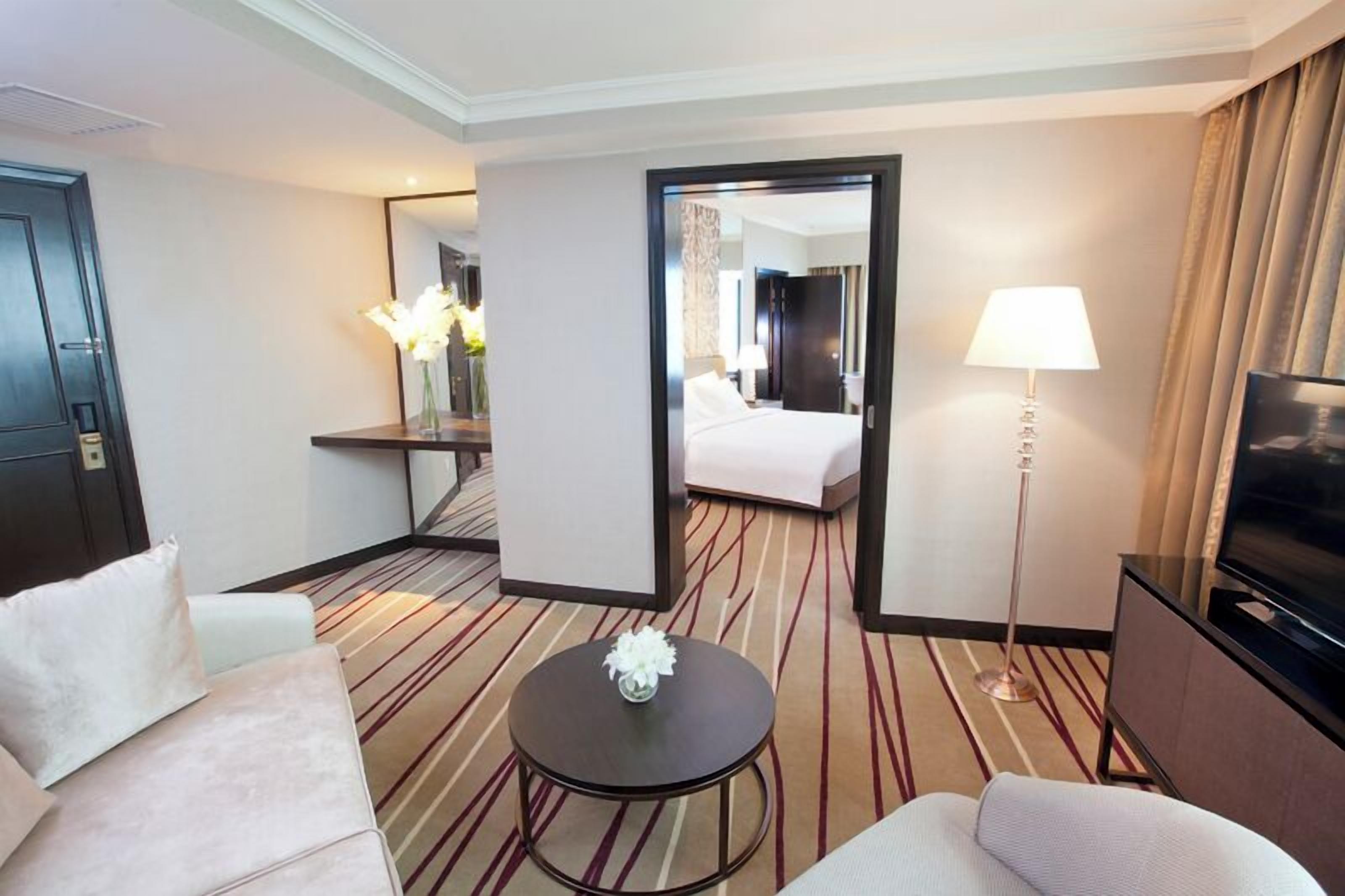Een hotelkamer met een bed, televisie, bureau en stoel.