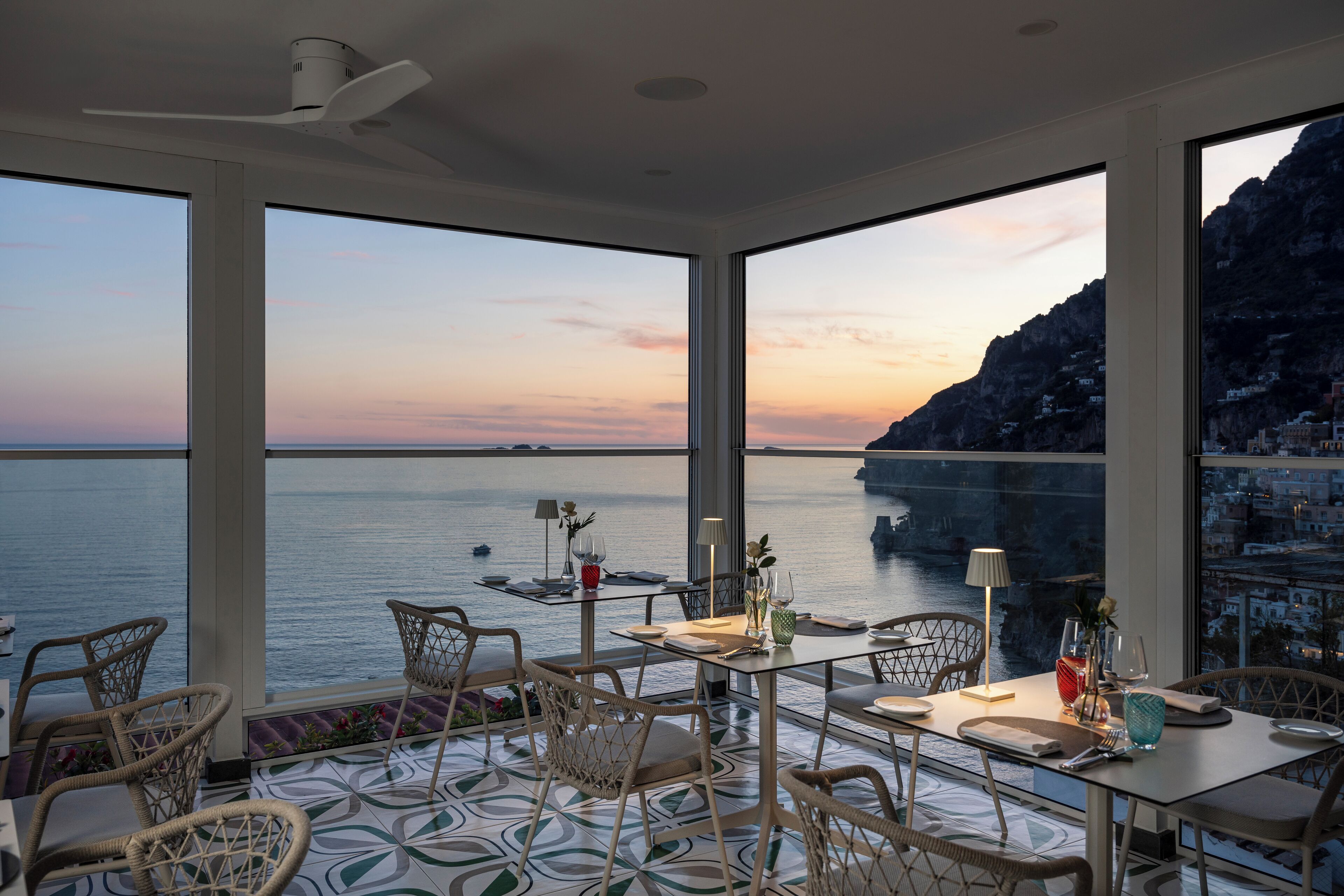 Un espace repas offrant une vue sur la mer et sur une côte montagneuse.